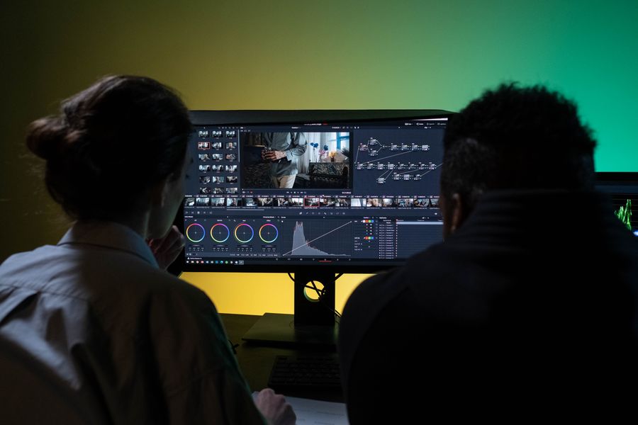 A studio workspace with editing screens, framed in low light.