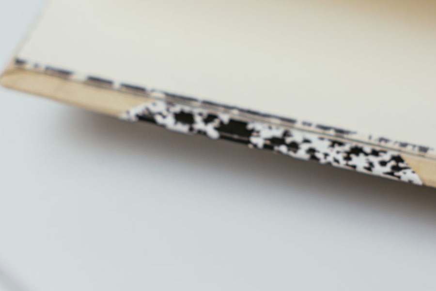 A grid-paper notebook and pen resting on a wooden desk.